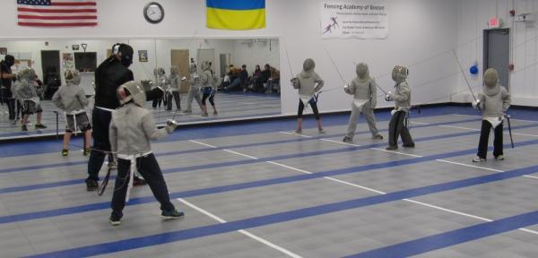 Youth fencers competing on the strips at Fencing Academy of Boston in Watertown