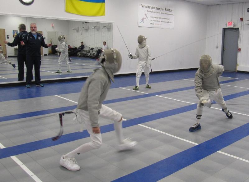 FAB coach instructing a youth beginner during saber fencing practice